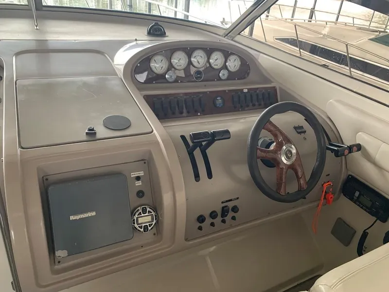 Slide: The Image of 1999 Regal 402 boat dashboard with steering wheel and control panel. - 23