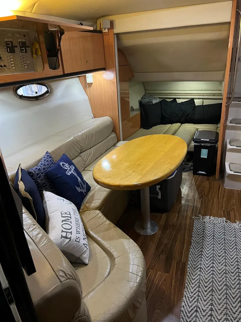 Slide: The Image of 1999 Regal 402 yacht interior with cozy seating, wooden table, and nautical-themed decor. - 28