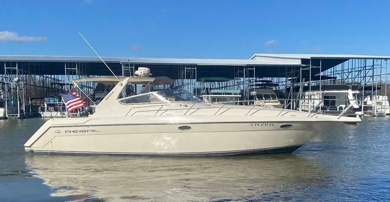 Slide: The Image of 1999 Regal 402 yacht docked at marina under clear blue sky. - 3