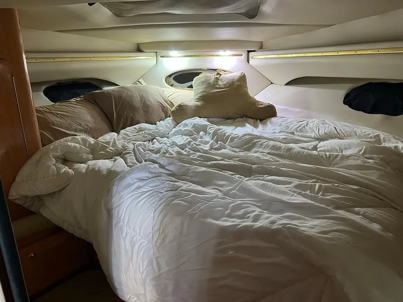 Slide: The Image of Cozy cabin interior of a 1999 Regal 402 boat with a plush bed and pillows. - 32