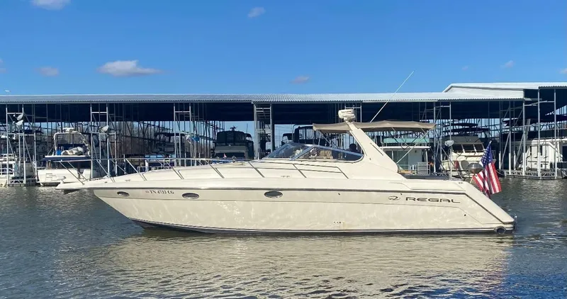 Slide: The Image of 1999 Regal 402 yacht docked at marina under clear blue sky. - 6
