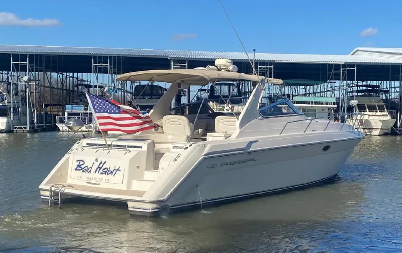Slide: The Image of 1999 Regal 402 boat with American flag docked at marina. - 7
