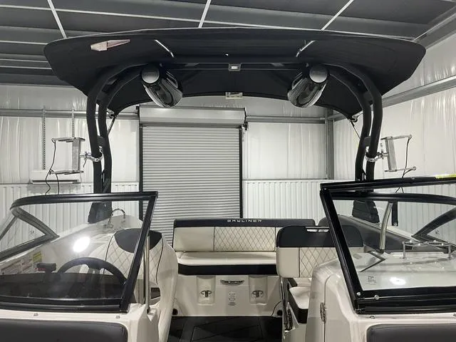 Slide: The Image of 2023 Bayliner DX2250 boat interior with seating and speakers in a garage setting. - 11