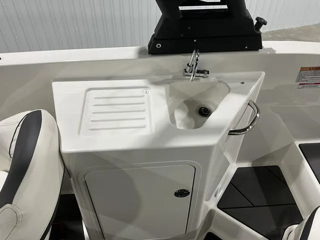 Slide: The Image of 2023 Bayliner DX2250 boat interior with sink and storage compartment. - 14