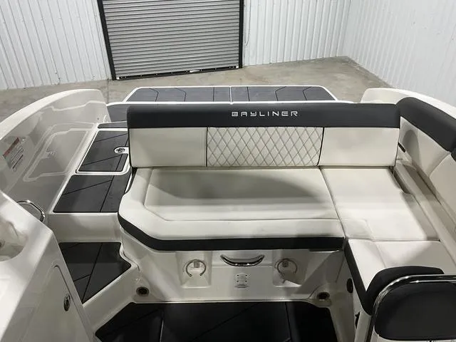 Slide: The Image of 2023 Bayliner DX2250 boat interior with cushioned seating and storage compartments. - 17