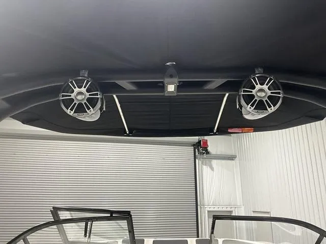 Slide: The Image of 2023 Bayliner DX2250 boat interior with speakers and canopy. - 18