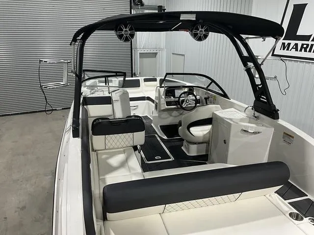 Slide: The Image of 2023 Bayliner DX2250 boat interior with modern seating and steering wheel in a showroom. - 20
