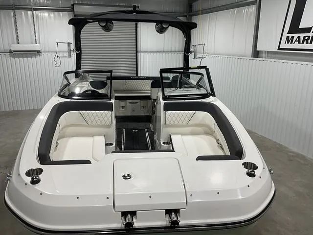 Slide: The Image of 2023 Bayliner DX2250 boat interior with white seating in a showroom. - 8