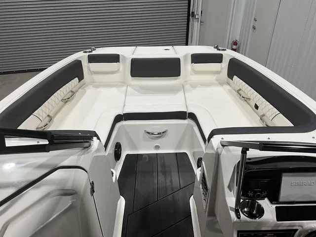 Slide: The Image of 2023 Bayliner DX2250 boat interior with white and gray seating, modern dashboard, and spacious layout. - 9