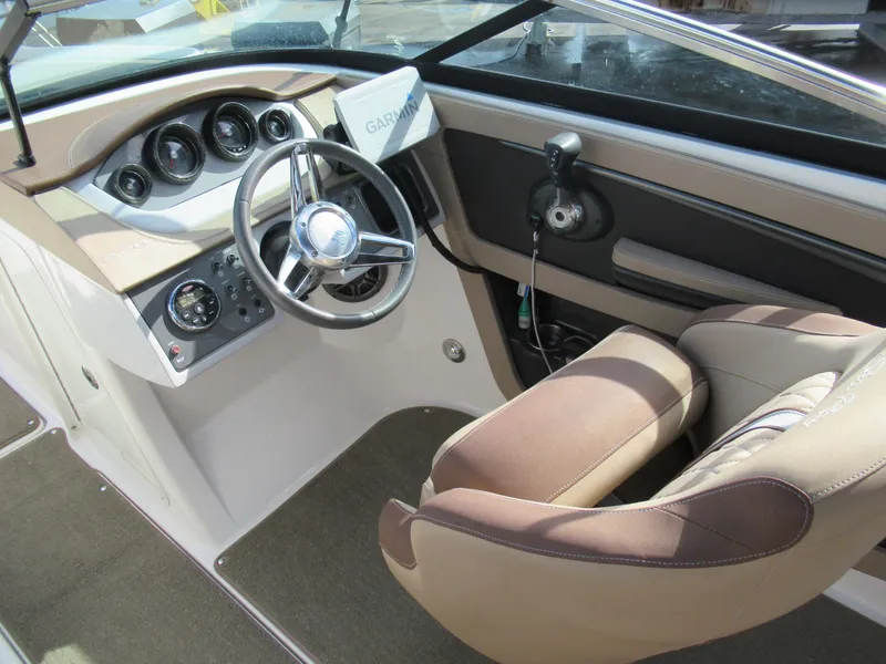 Slide: The Image of 2016 Sea Ray SunDeck 220 boat interior with steering wheel and dashboard controls. - 10