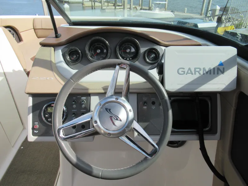 Slide: The Image of 2016 Sea Ray SunDeck 220 dashboard with Garmin navigation system and steering wheel. - 12