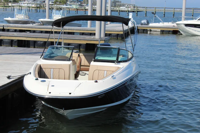 Slide: The Image of 2016 Sea Ray SunDeck 220 boat docked at marina, featuring sleek design and spacious seating. - 15