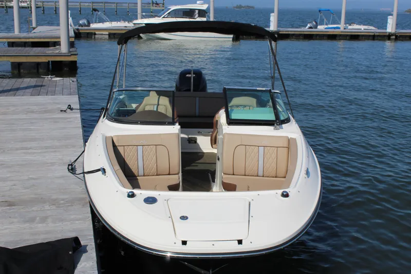 Slide: The Image of 2016 Sea Ray SunDeck 220 boat docked at marina, featuring open seating and sleek design. - 22