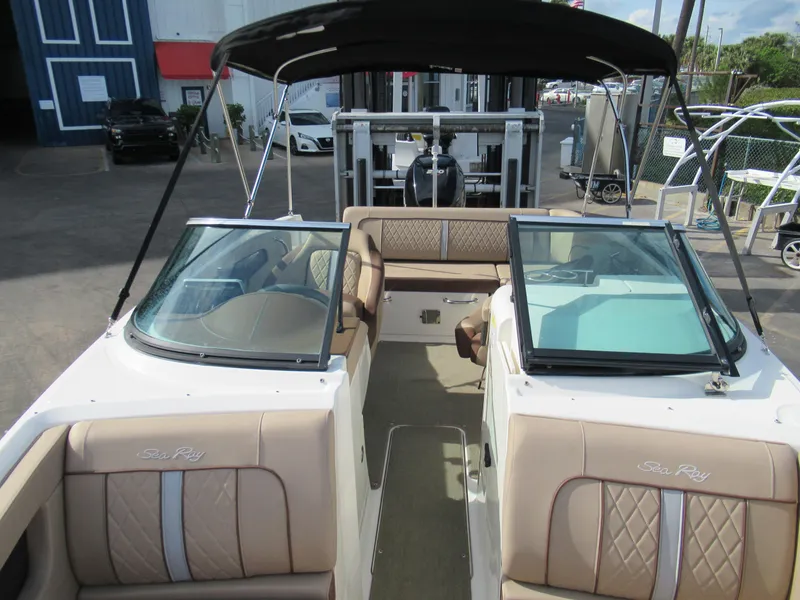 Slide: The Image of 2016 Sea Ray SunDeck 220 boat with tan seating and black canopy in a marina. - 8