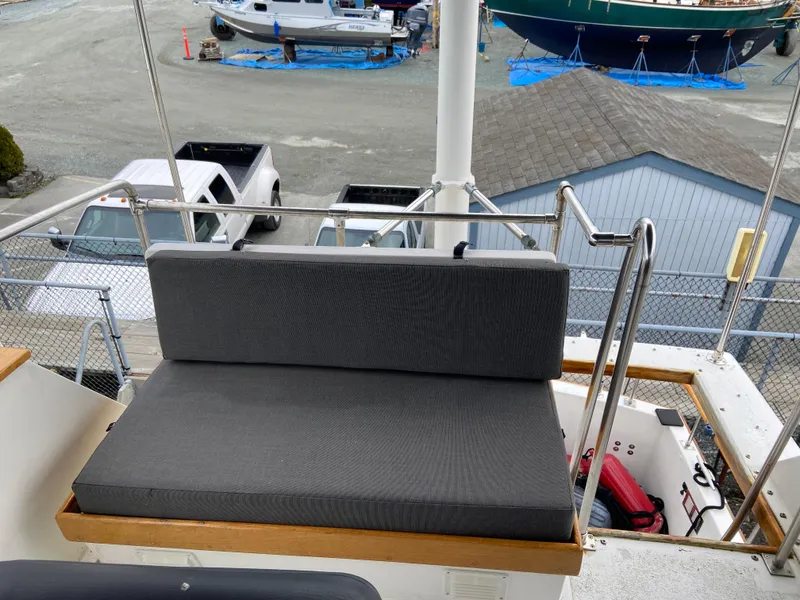 Slide: The Image of 1981 Rough Water 37 Sedan boat with cushioned seating on deck. - 11