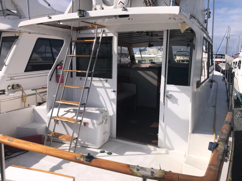 Slide: The Image of 1981 Rough Water 37 Sedan boat with open cabin and ladder, docked at marina. - 12