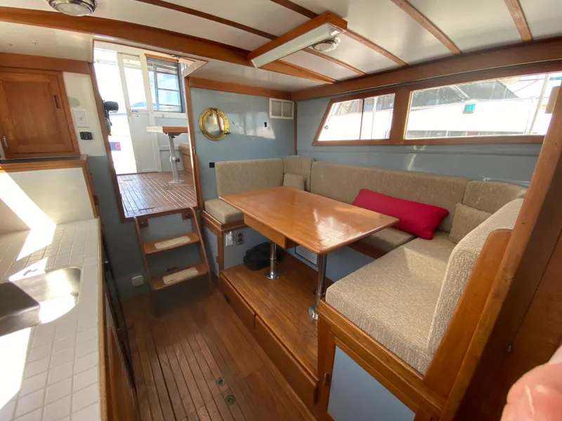 Slide: The Image of Interior of 1981 Rough Water 37 Sedan with wooden dining area and cushioned seating. - 17