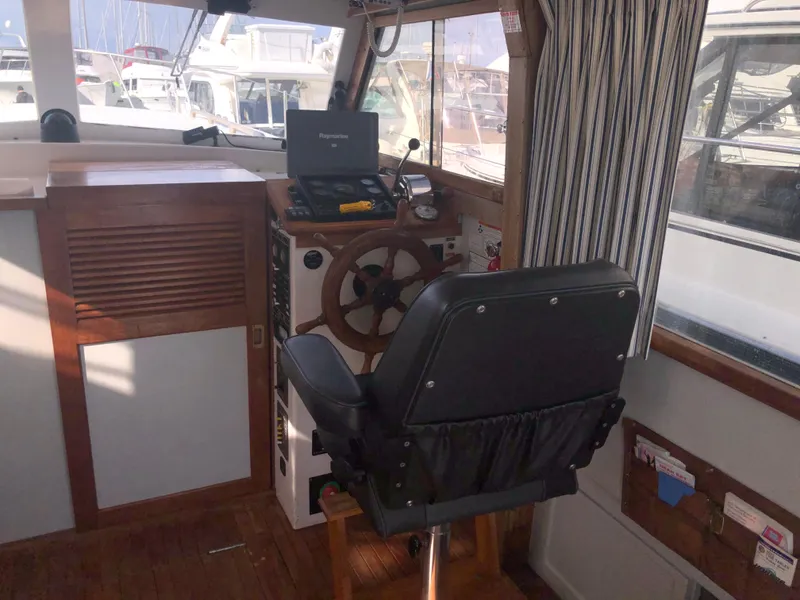 Slide: The Image of 1981 Rough Water 37 Sedan boat interior with steering wheel and navigation equipment. - 21