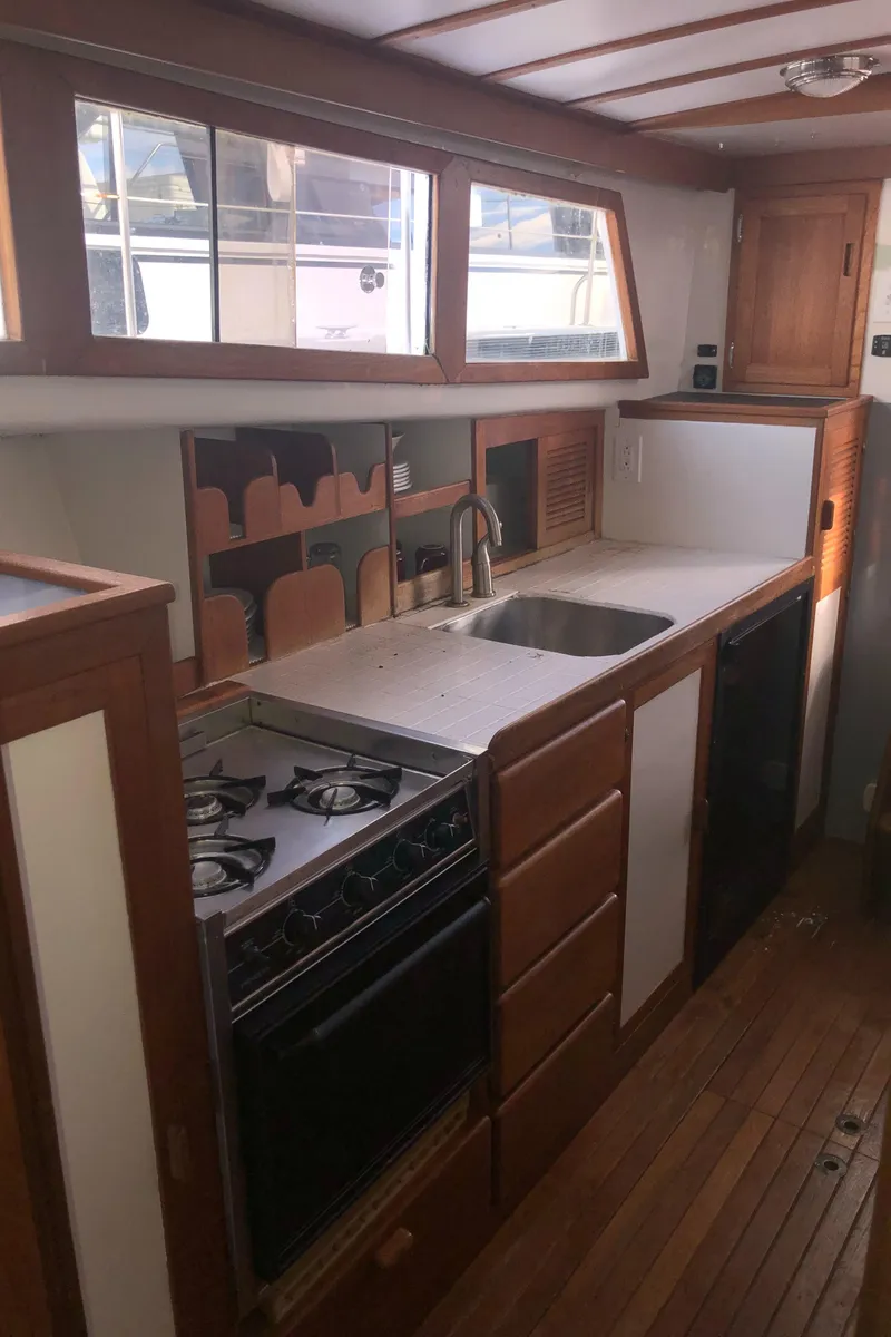 Slide: The Image of 1981 Rough Water 37 Sedan kitchen with wooden cabinets, stove, and sink. - 32