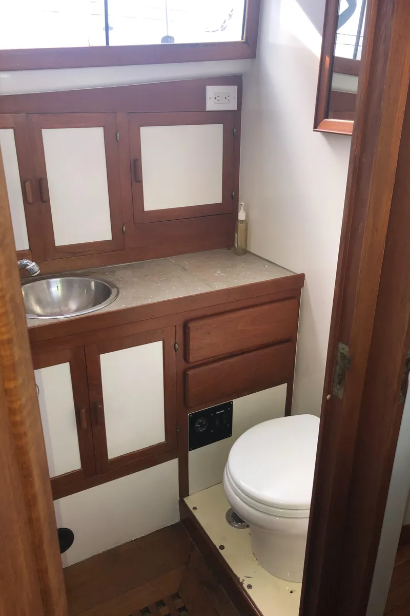 Slide: The Image of 1981 Rough Water 37 Sedan boat bathroom with wooden cabinets and compact design. - 37