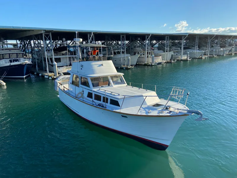 Slide: The Image of 1981 Rough Water 37 Sedan boat docked in marina under clear blue sky. - 4