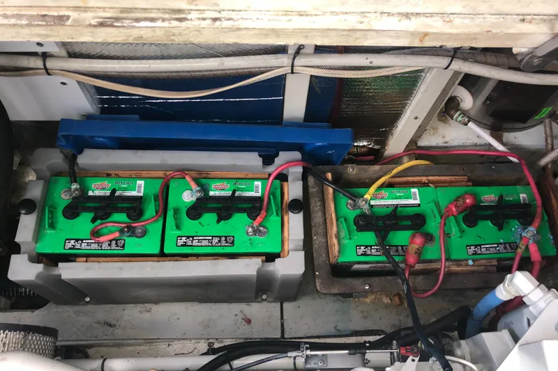 Slide: The Image of Battery compartment of a 1981 Rough Water 37 Sedan boat, featuring three green batteries. - 41