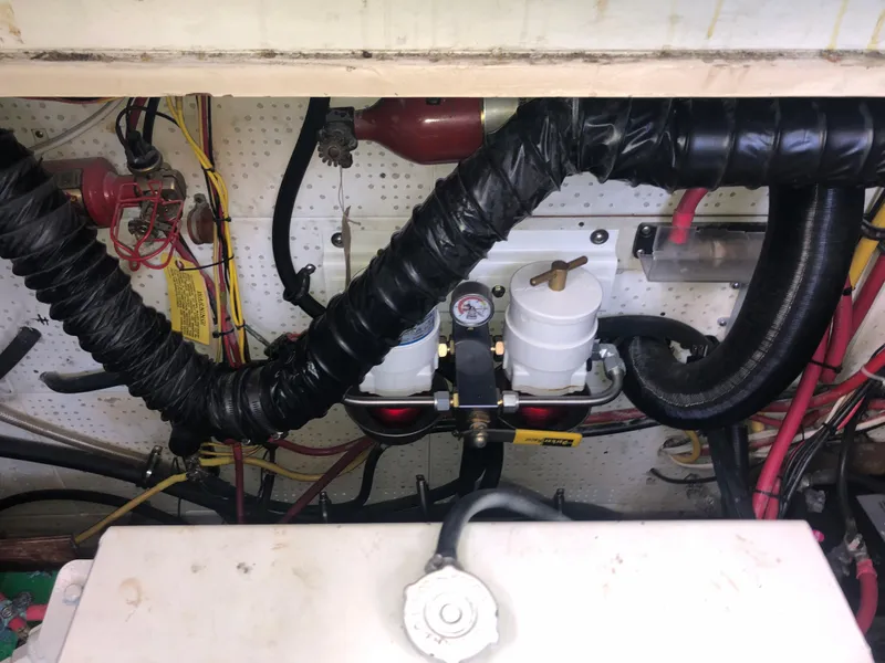 Slide: The Image of Engine compartment of 1981 Rough Water 37 Sedan with hoses and wiring. - 43