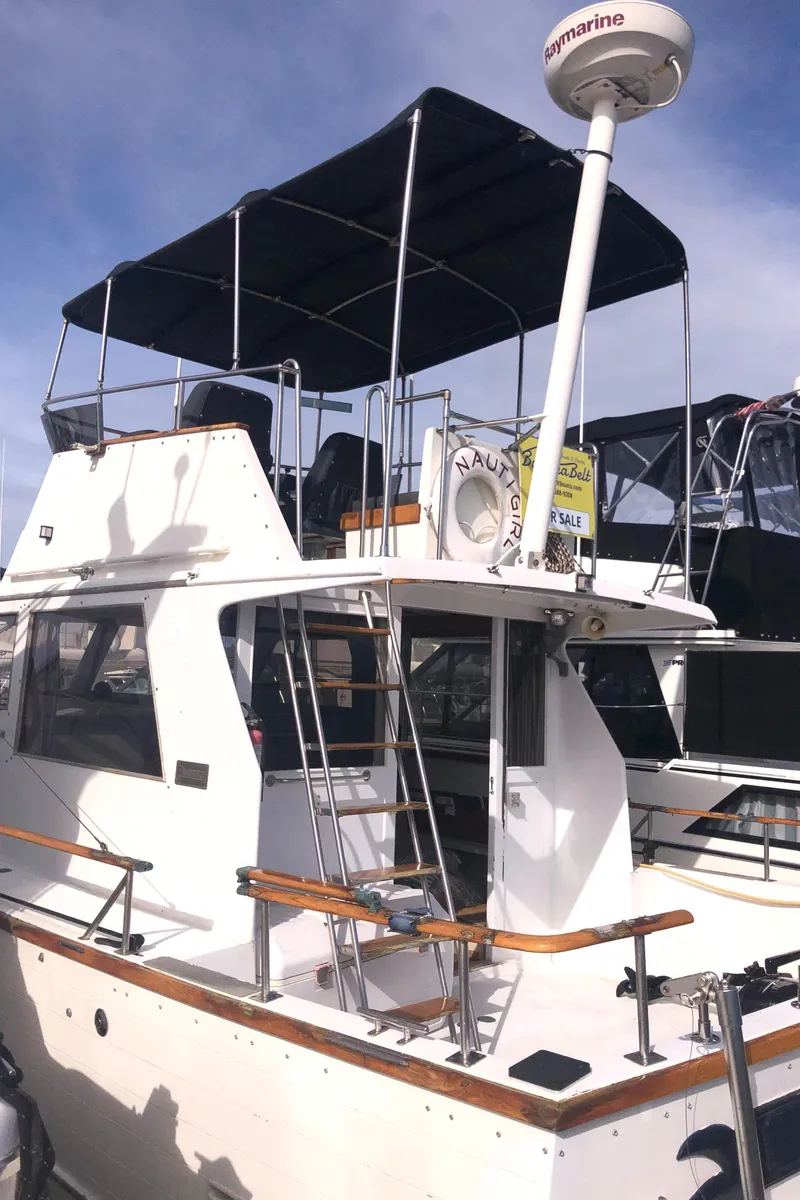 Slide: The Image of 1981 Rough Water 37 Sedan boat with upper deck and radar, docked under clear skies. - 5