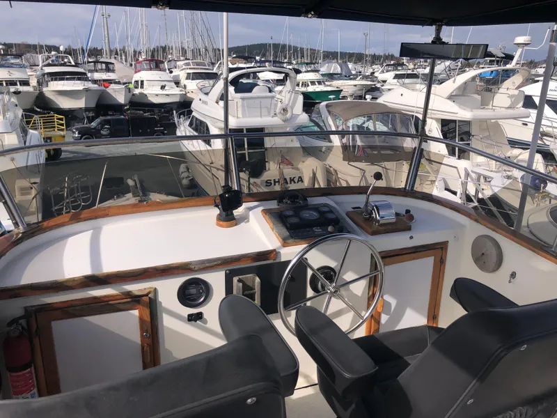 Slide: The Image of Cockpit view of 1981 Rough Water 37 Sedan in a marina, surrounded by boats. - 6