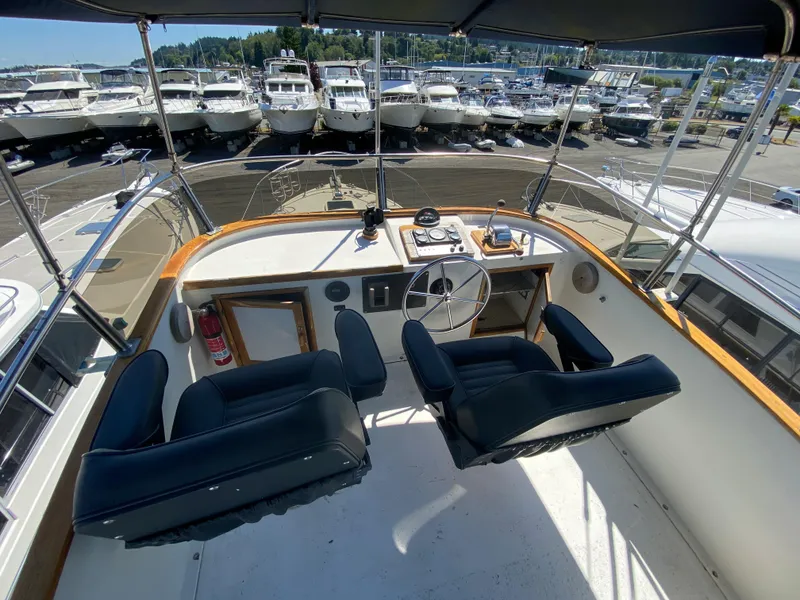 Slide: The Image of 1981 Rough Water 37 Sedan boat cockpit with dual seats and marina view. - 7