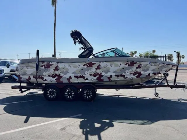 Slide: The Image of 2022 MasterCraft X26 boat with camouflage design on a trailer in a parking lot. - 5