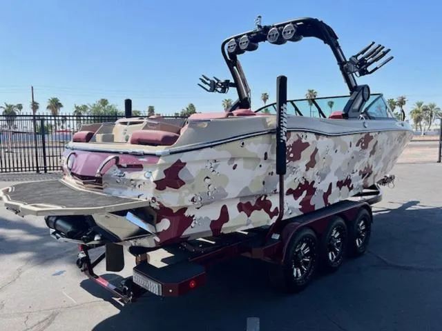 Slide: The Image of 2022 MasterCraft X26 boat with camouflage design on a triple-axle trailer. - 6