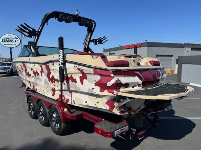 Slide: The Image of 2022 MasterCraft X26 boat with red camouflage design on a trailer. - 8