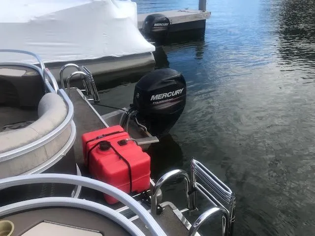 Slide: The Image of 2018 Princecraft Pontoon boat with Mercury outboard motor docked on calm water. - 4