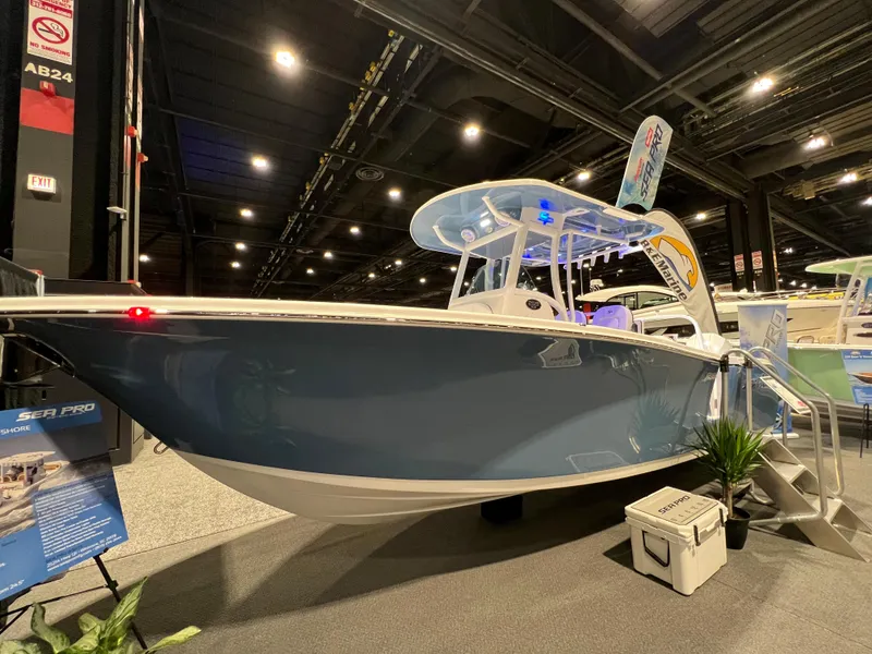 Slide: The Image of 2023 Sea Pro 259 Deep V CC boat displayed at an indoor boat show. - 12