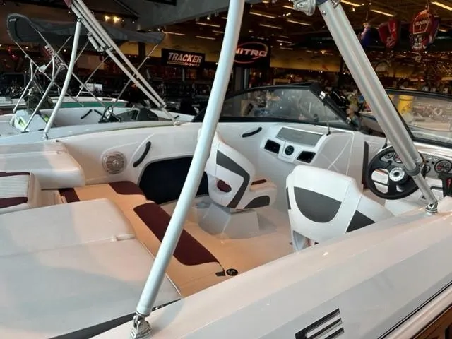 Slide: The Image of 2023 Tahoe 185 S boat interior with white and maroon seating, steering wheel, and dashboard. - 6