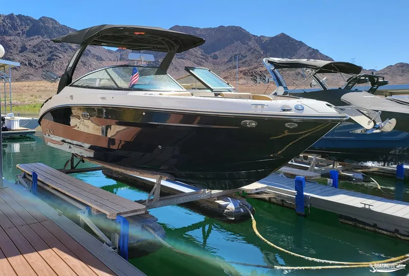 Slide: The Image of 2024 Sea Ray SLX 260 Surf boat docked on a sunny day. - 0