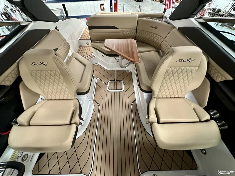 Slide: The Image of Luxurious interior of 2024 Sea Ray SLX 260 Surf boat with beige seating and wood accents. - 11