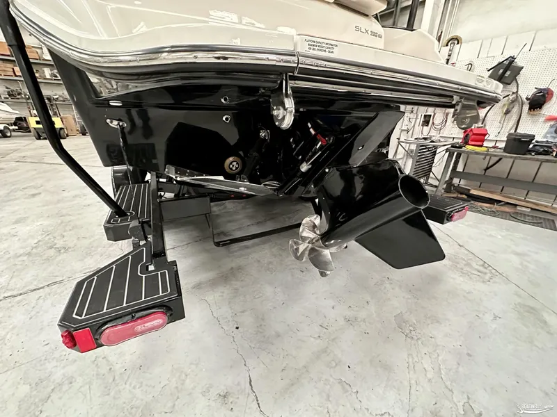 Slide: The Image of 2024 Sea Ray SLX 260 Surf boat in a workshop, showcasing the propeller and stern details. - 17