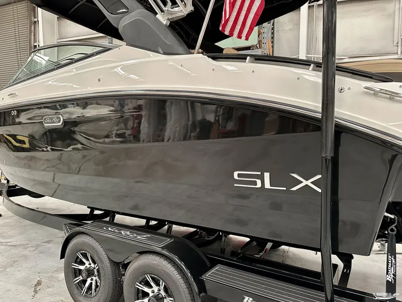 Slide: The Image of 2024 Sea Ray SLX 260 Surf boat on trailer in a garage. - 3