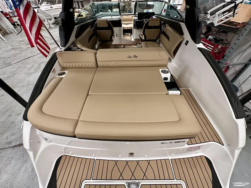 Slide: The Image of 2024 Sea Ray SLX 260 Surf boat interior with tan seating and American flag. - 7