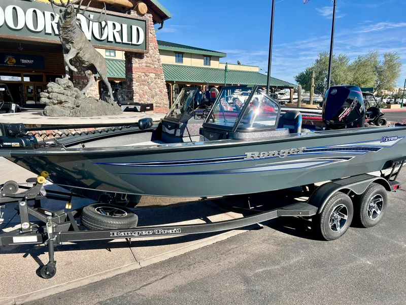Slide: The Image of 2023 Ranger VX1788 WT fishing boat on a trailer outside an outdoor store. - 1