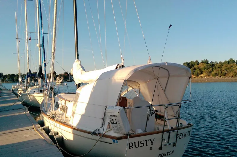 The Image of 1979 Pearson 323 sailboat docked, named "Rusty Pelican," with a white canopy, in Boston harbor. - 0