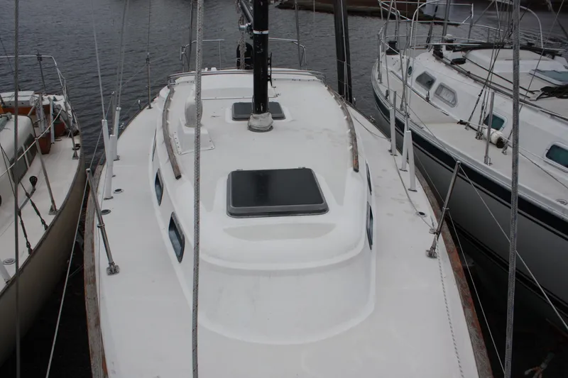 Slide: The Image of 1979 Pearson 323 sailboat docked, showcasing deck and cabin layout. - 10