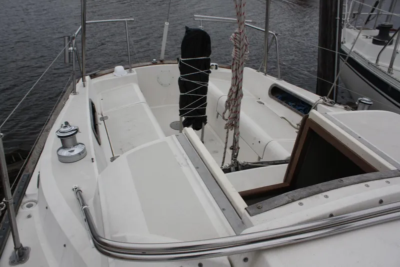 Slide: The Image of 1979 Pearson 323 sailboat cockpit with winches and ropes, docked on calm water. - 11