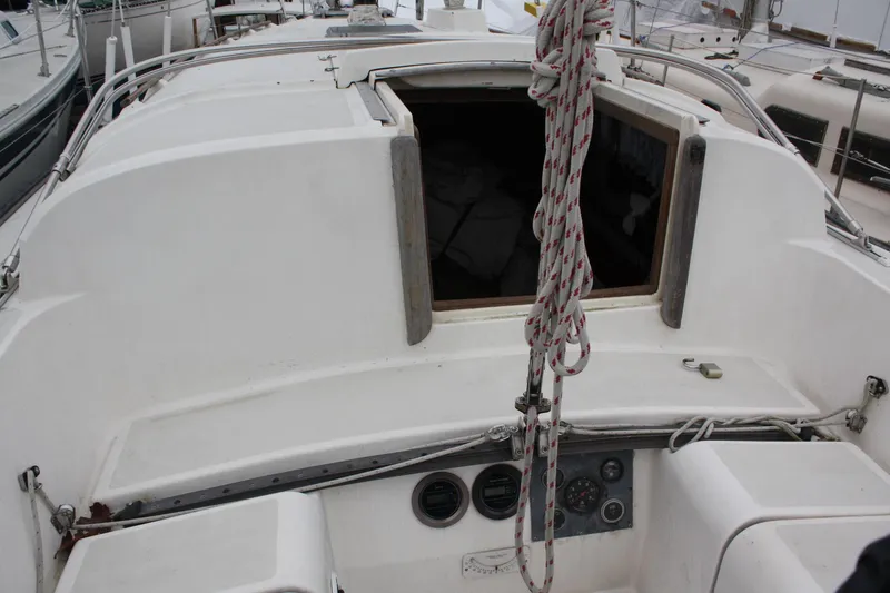 Slide: The Image of 1979 Pearson 323 sailboat cockpit with open hatch and nautical equipment. - 12