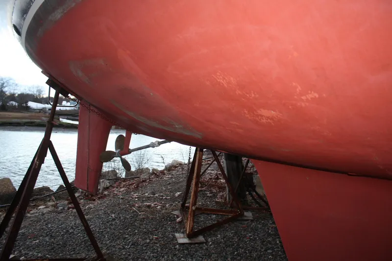 Slide: The Image of Bottom view of a 1979 Pearson 323 sailboat on a stand by the water. - 14