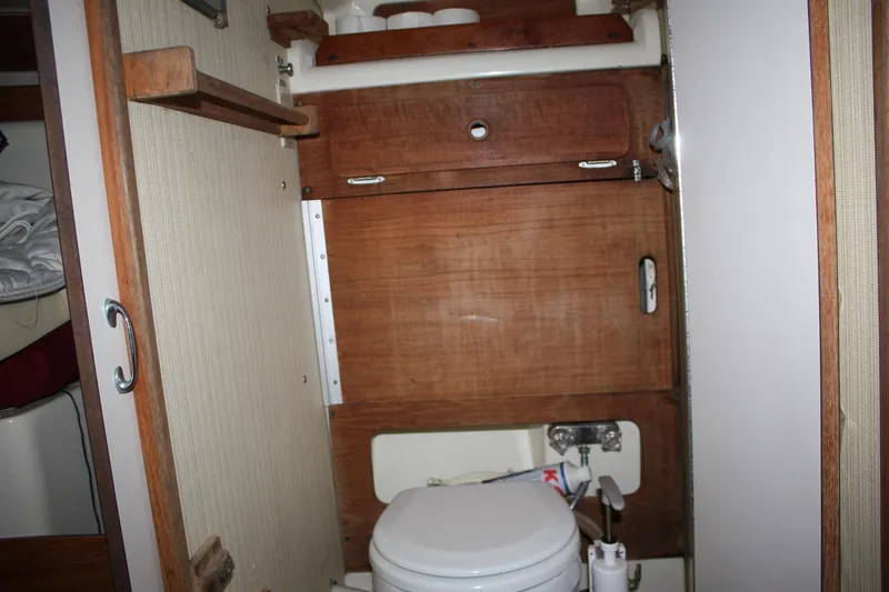 Slide: The Image of 1979 Pearson 323 yacht bathroom with wooden cabinetry and compact toilet. - 18