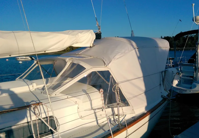 Slide: The Image of 1979 Pearson 323 sailboat with white canopy, docked on a sunny day. - 2