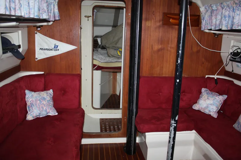 Slide: The Image of Interior of a 1979 Pearson 323 sailboat with red seating and wood paneling. - 22